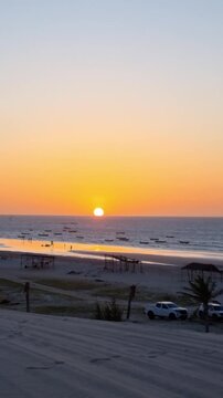 Spectacular Orange Sunset with Silhouettes of People, Kite and Jangada. Praia do Prea, Ceara, Brazil