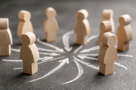 Wooden figurines arranged in a circle with chalk arrows pointing inward symbolizing teamwork collaboration and effective communication in a group setting