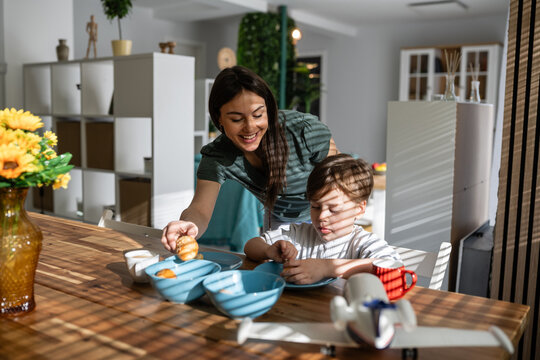 Mother and child enjoying family breakfast together in morning sun