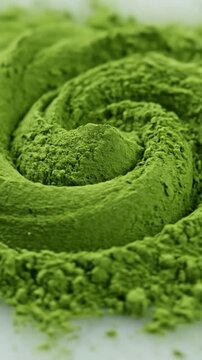 A close up view of vibrant green tea powder arranged in a beautiful spiral pattern on a white surface