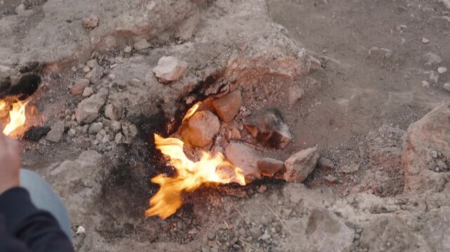 Person Roasting Marshmallows Over the Eternal Flames at the Chimaera in Turkey, Using the Natural Fire Emerging from the Rocks for Cooking, Unique Outdoor Experience