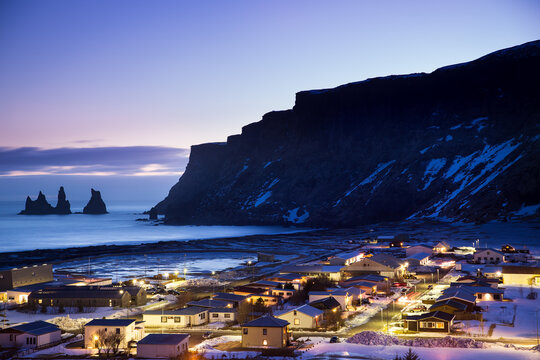 Aerial view of illuminated houses in a coastal village at night, Vik, Myrdal,  Southern Region, Iceland