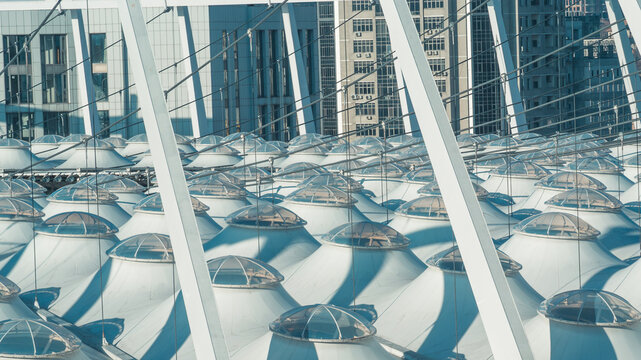 Sunlight and shadows creating dynamic contrasts on the white textile canopy of an arena