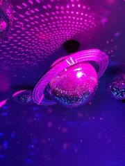 Disco ball in the shape of Saturn planet on purple background © Palina