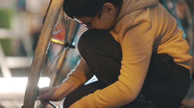 Person inflating bicycle tire at night