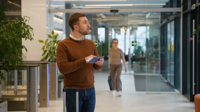 Male traveler at the airport and looking at the flight schedule. Flight delay