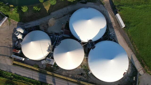 Aerial view of agricultural complex of barns and biogas production domes and storage tanks, bio renewable energy generation from rural panorama landscape Europe