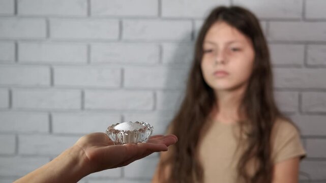 Young girl refusing to eat salt. Teenage girl demonstrating a strong refusal of salt being offered to her by making a stop gesture with her hands, symbolizing a commitment to a healthy diet
