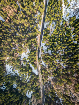 Aerial road through Jura forest with snow and trees