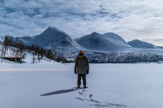Winter hiker in Tromso, Norway, facing Lapland peaks
