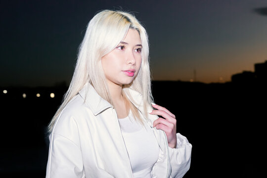Flash portrait of Urban Gen Z girl at dusk skyline