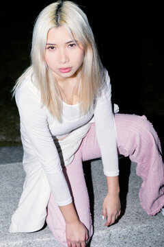 Urban Gen Z girl posing at night with flash street style
