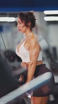 Muscular woman doing triceps pushdowns exercise