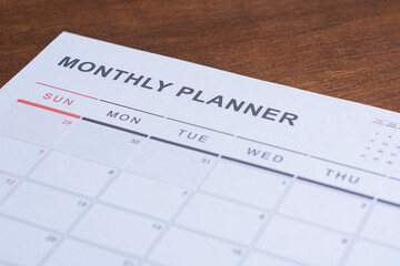 Obraz premium Monthly planner calendar on desk showing schedule organization and time management. Concept of productivity, planning tasks, business workflow, deadlines and personal organization.