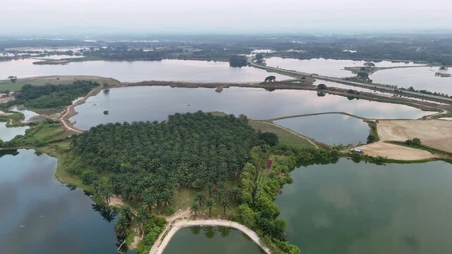 Drone view highlights vast abandoned tin mines of Kampar with water filled pits and lush surroundings.