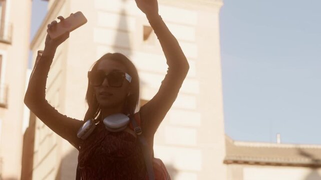 Happy young woman dancing in the city street