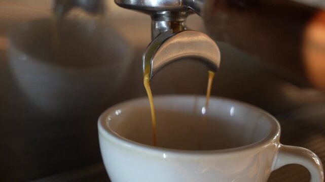 Fresh Espresso Pouring from Portafilter into Cup Close Up with Crema
