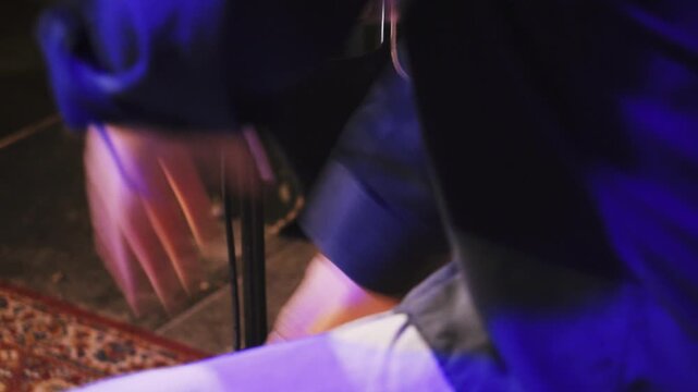 Nahaufnahme von H&auml;nden beim Spielen einer Cajon mit unscharfem K&ouml;rper im Hintergrund, rhythmische Percussion Szene in Full HD