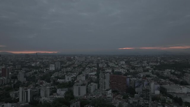 Aerial panoramic view flying sideways over Colonia Condesa on overcast sunrise morning, Mexico City