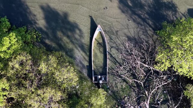 Aerial broken boat stranded in mangrove mudflat