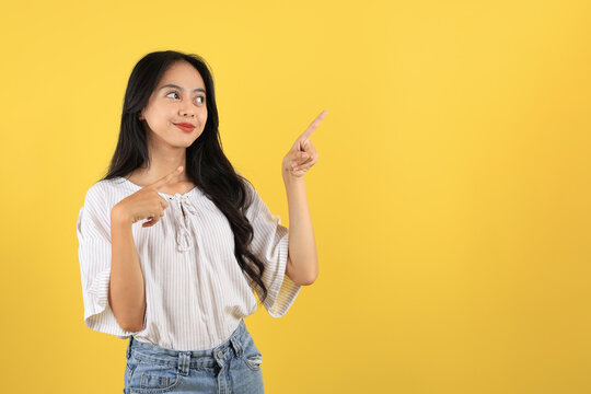 Asian Teenager with Long Hair and Casual Fashion, Pointing on Top