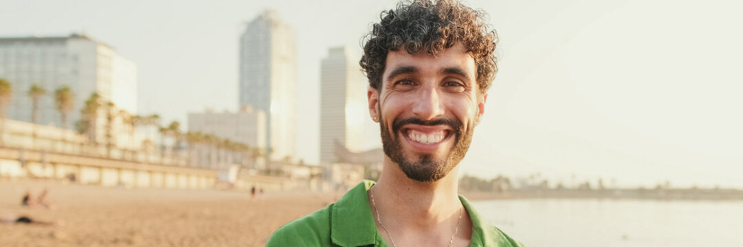 Close-up of young guy looking at the camera with smile. Panoramic
