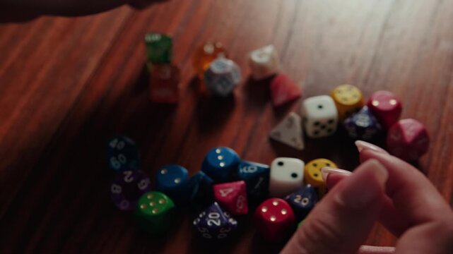 Hands Dropping Colorful Polyhedral Dice for Tabletop Game