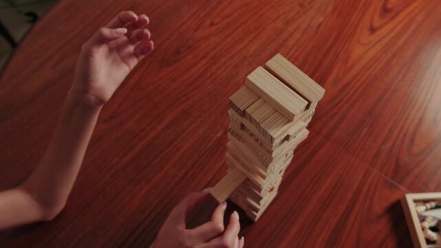 Skillful Hands Play Jenga, Removing Wooden Block