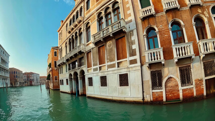 Fototapeta premium Gondola gliding through calm waters by architecture concept. Beautiful historic buildings along a tranquil canal in Venice.