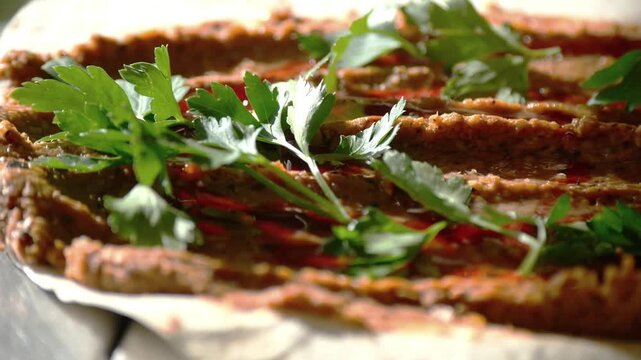 Close up of delicious turkish cig kofte with parsley and chili oil.