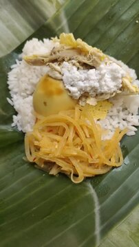 A delicious Nasi Liwet served on fresh banana leaves. Nasi Liwet Solo is a traditional dish from Surakarta or Solo, Central Java, Indonesia, consisting of fragrant rice cooked with coconut milk.