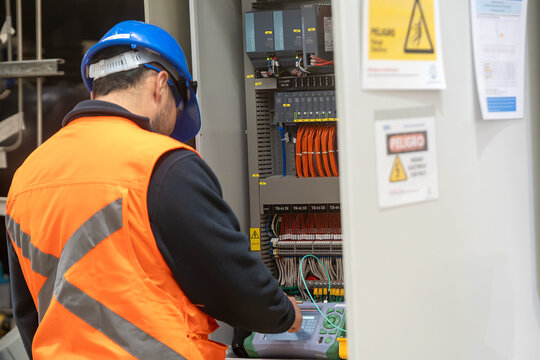 Two technicians measure the signal level in the fiber optic cable. Serving a central router in a server room. Two people work in a modern data center.