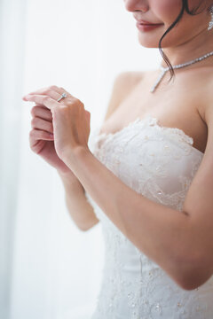 Beautiful Asian bride looking at her wedding ring with excitement