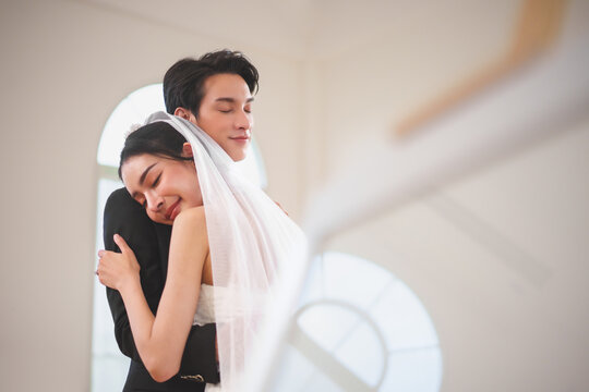 Romantic Asian wedding couple embracing each other with happiness