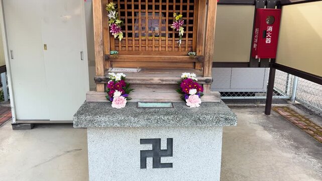 Small Wooden Buddhist Shrine with Manji Symbol and Flower Offerings in Kyoto
