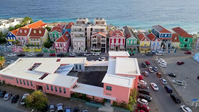 Drone view of Pietermaai waterfront at sunset with colorful heritage buildings and ocean beside the district.