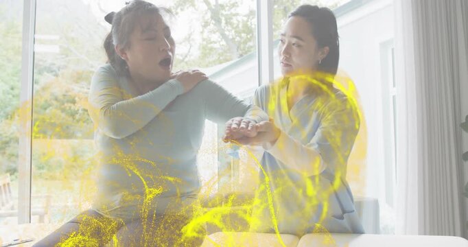 Woman reaching left hand and moaning, nurse checking wrist, yellow swirling around hands for clinic