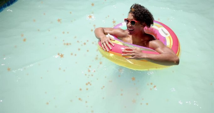 Adult man floating in pale pool in donut, topcam starting laughing, red-shades, gold stars for ads