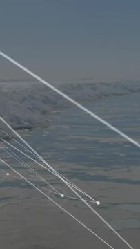 Vertical video: Net growing over surf as camera shifting, pulsing nodes mapping ocean tech