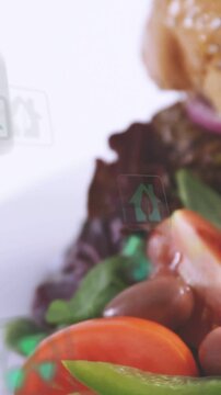 Vertical video: Plate edge appearing, camera panning, icons floating over burger, showing eco stats