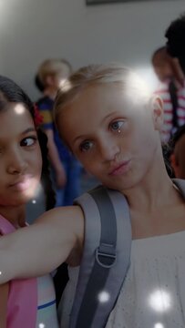 Vertical video: Blonde girl extending arm, posing selfie in school, gray bag, flares crossing faces