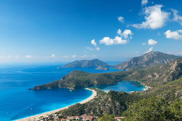 Obraz premium Beautiful view of Oludeniz beach, blue lagoon with turquoise water, Lycia coast from high cliff. Summer day walk by Lycian way at family vacation in Mediterranean Sea, Fethye, Antalya region, Turkey