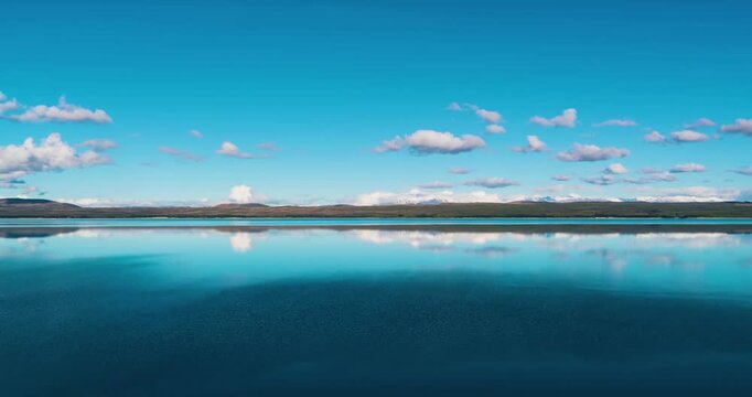 Stunning aerial time-lapse of Sayram Lake in Xinjiang with snow mountains, grassland, river, and highway, showcasing breathtaking natural beauty.