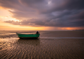 Fototapeta premium Fishing boat on sandy beach sunset