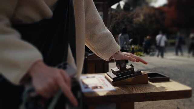 Tourist woman using a japanese commemorative stamp