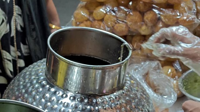 Close up of Indian street food vendor serving fresh Panipuri at a local market stall