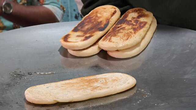 Close up of Kulcha being toasted with butter on a griddle