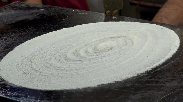 Crispy plain dosa on a hot flat tawa griddle