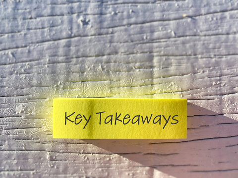 Key takeaways text written on sticky note on wooden background, concept of learning summary and important points.