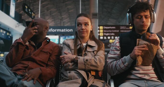 Highly Sensitive Passenger Sits Amidst Chaos of Terminal, Showing Signs Sensory Processing Struggle. Woman Remains Still and Focused, Regulating Emotions Against Loud Environment. Sensory Sensitivity.